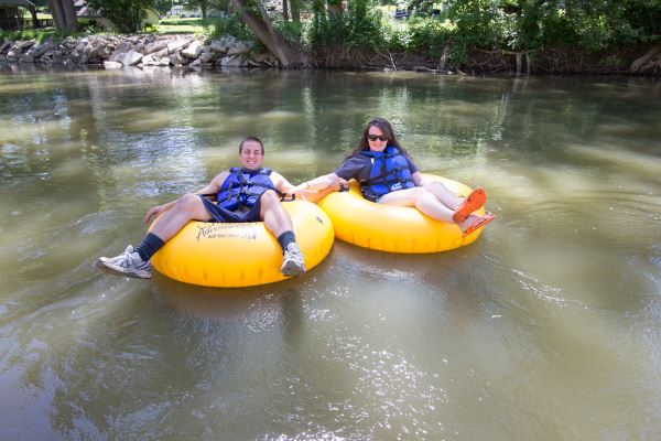 a couple floating on tubes on a river